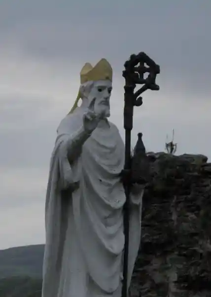 A statue holding a crosier, the crosier having a solar cross